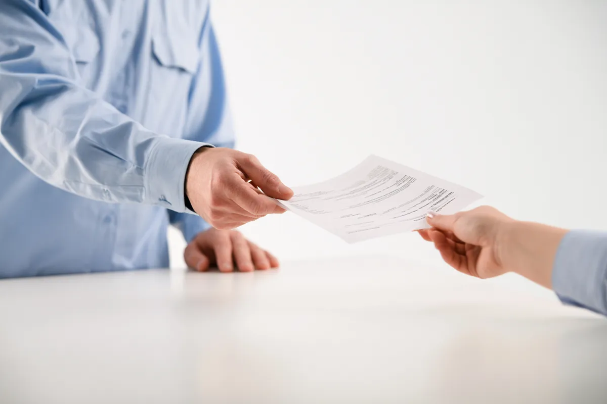 Service advisor handing over an auto repair estimate sheet